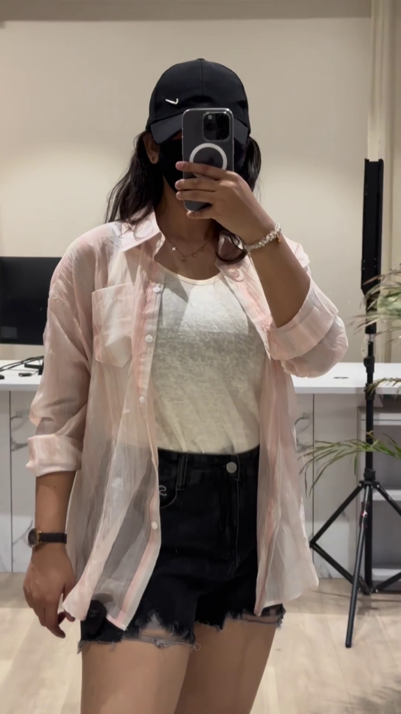 Casual Layered Outfit: Pink Button-Down Shirt, Tank Top, and Denim Shorts - Photo 3