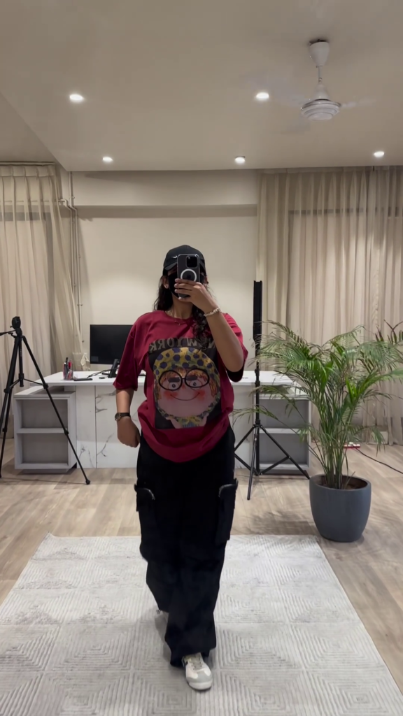 Urban Chic Outfit: White Graphic Tee, Rust Cargo Pants, and Black Cap - Photo 6