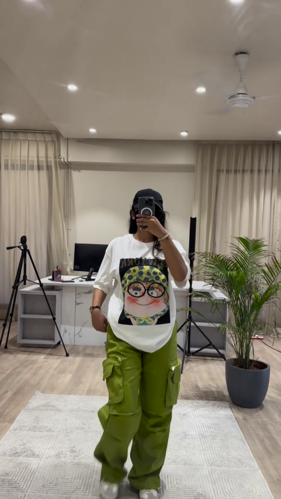 Urban Chic Outfit: White Graphic Tee, Rust Cargo Pants, and Black Cap - Photo 5