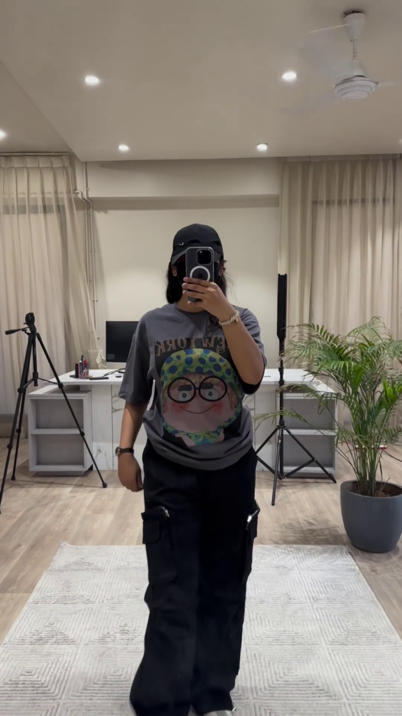 Urban Chic Outfit: White Graphic Tee, Rust Cargo Pants, and Black Cap - Photo 4