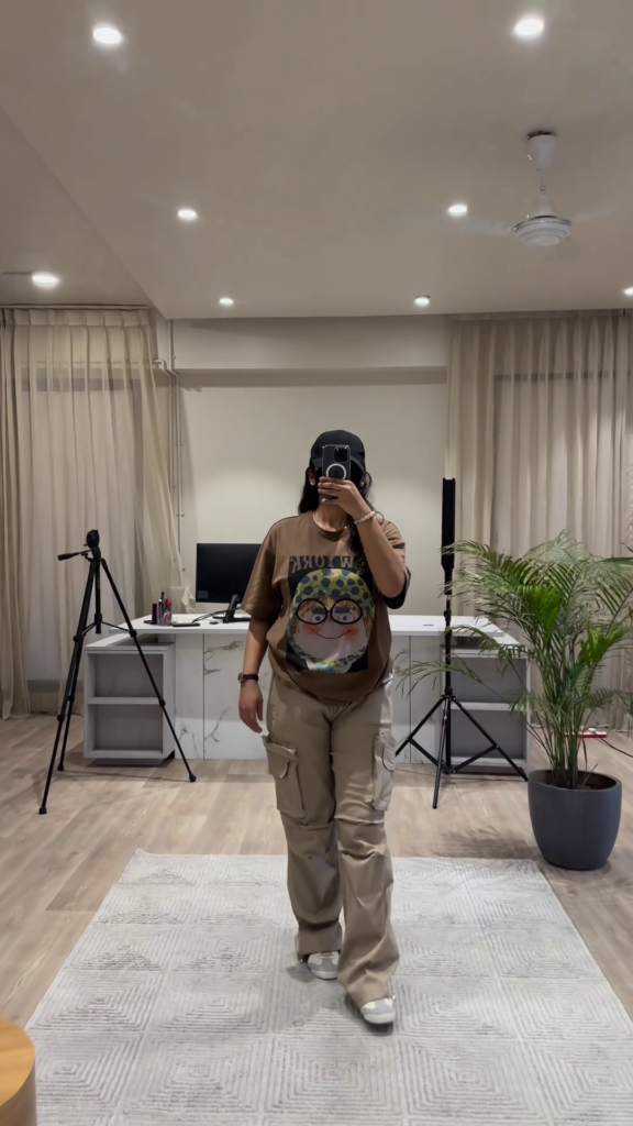 Urban Chic Outfit: White Graphic Tee, Rust Cargo Pants, and Black Cap - Photo 3