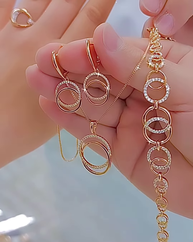 Elegant Rose Gold Tone Jewelry Set with Interlocking Circle Design and Sparkling Accents - Photo 1